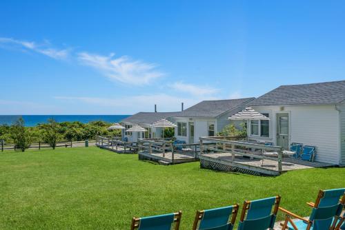 a yard with chairs and a house and the ocean at Breakers Montauk in Montauk