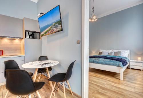 una piccola stanza con un tavolo, sedie e un letto di Apartamenty Teatralna Świnoujście a Świnoujście