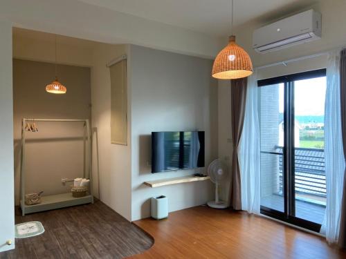 ein Wohnzimmer mit einem TV und einem großen Fenster in der Unterkunft 嫚悅文旅 in Dayi