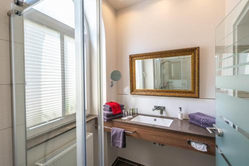 a bathroom with a sink and a mirror at Hotel am Markt Bacharach in Bacharach