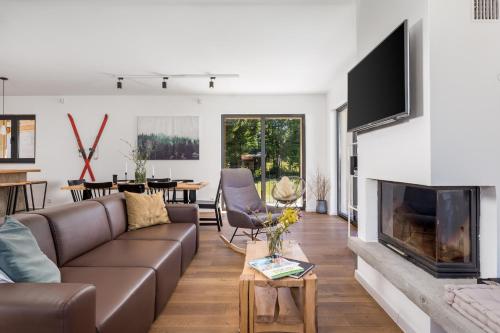 sala de estar con sofá y chimenea en Modern Alpine Monsalbius Chalet, en Baške Oštarije