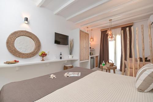 a bedroom with a bed with a mirror on the wall at Ruby of Naxos in Agios Prokopios