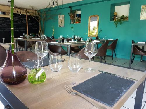 een tafel in een restaurant met wijnglazen erop bij Les Bruyeres in Plélan-le-Grand