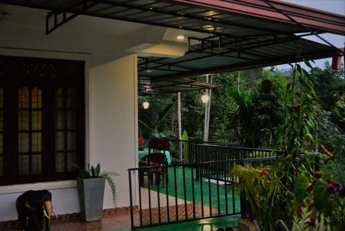 a house with a patio with a fence and some plants at Ella Panorama Villa in Ella