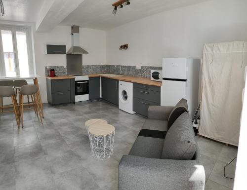 un salon avec un canapé et une cuisine dans l'établissement LA MAISON DE GILYDIE, à Chabris