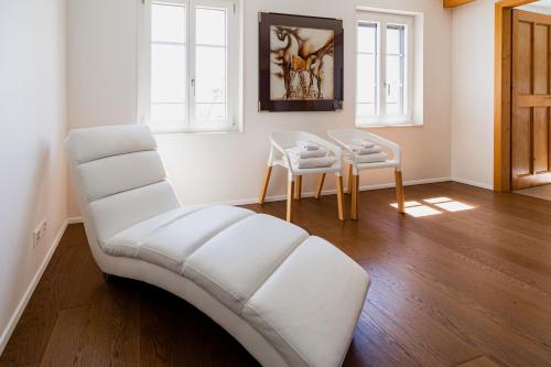 a living room with a white couch and two chairs at La Ferme de la Praz - Rooms with a View in La Praz