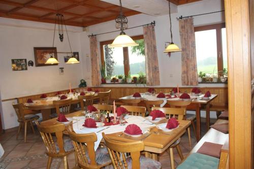 uma sala de jantar com mesas e cadeiras de madeira em Gasthof Grüner Baum "Kongo" em Amtzell