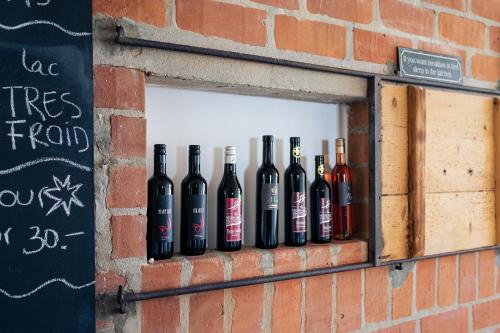 a group of bottles of wine in a window at La Ferme de la Praz - Rooms with a View in La Praz