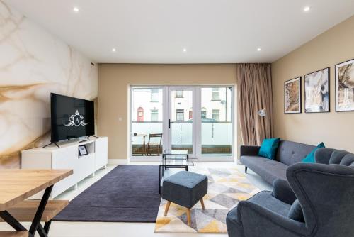 a living room with a couch and a tv at For Work Trips - Quiet & Ready to Go - Apartment 1 in Gillingham
