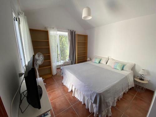 Schlafzimmer mit einem Bett und einem Flachbild-TV in der Unterkunft Charming 1 bedroom suite with shared kitchen next to Puerto Banus in Marbella