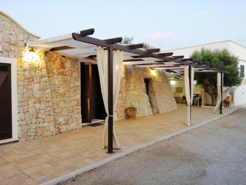 a pergola on a patio in front of a building at Santa Maria de Lu Trisciulu in Castrignano del Capo