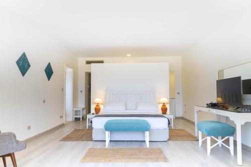 a bedroom with a bed and a desk and a tv at Caesar Bay Resort in Marsa Matruh