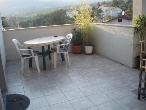 d'une terrasse avec une table et des chaises sur un balcon. dans l'établissement Apartments Hiper, à Matulji