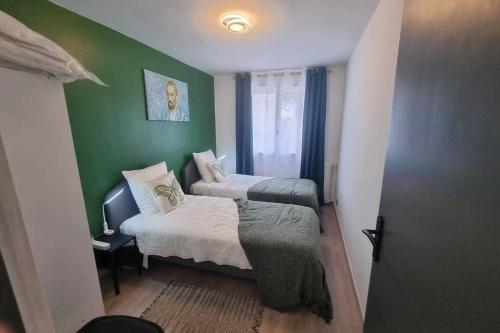 um quarto com 2 camas e uma parede verde em Superbe appartement 5 pièces - rénové 2021 em Avignon