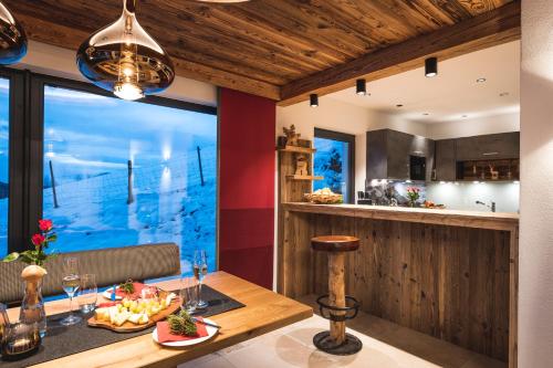 eine Küche und ein Esszimmer mit einem Tisch mit Essen drauf in der Unterkunft Chalet Steinbock mit üppigem Genusskorb für Zwei in Jungholz