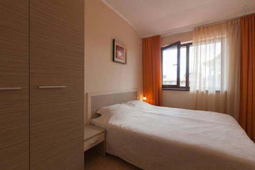 a bedroom with a white bed and a window at Apartments in Holiday Complex ROYAL SUN in Sunny Beach
