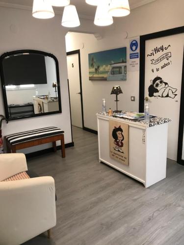uma sala de espera com um espelho e uma mesa em Alojamiento El Cantal em Santoña