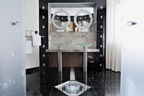 a bathroom with a sink and a mirror at Hotel Schwarzer Adler Innsbruck in Innsbruck
