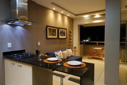a kitchen with a counter top and a living room at #3 Sofisticado Estúdio na Boaventura Da Silva in Belém