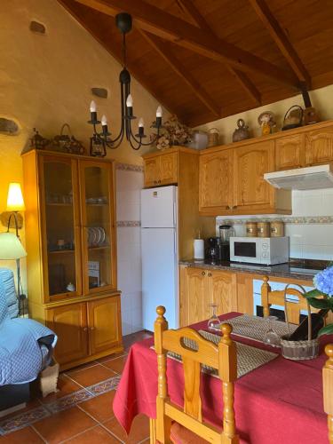 a kitchen with wooden cabinets and a white refrigerator at Casa Rural Las Rosas in Agulo