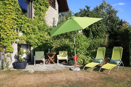 a group of chairs and an umbrella in the yard at Ferienwohnung Naturfreund in Lügde