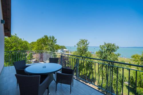 balcón con mesa, sillas y vistas al océano en Hotel La Riva en Siófok