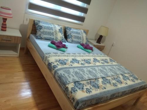 a bed with two shoes sitting on top of it at Apartman Vesna in Višegrad
