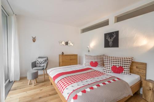 een slaapkamer met een bed met rode en witte kussens bij Ferienwohnung Wanderbar in Oberstdorf