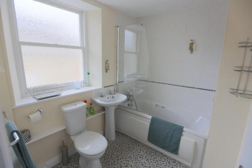 a white bathroom with a toilet and a sink at The Ramblers' Rest - Princetown in Princetown