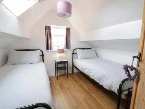 two twin beds in a room with a window at The Toll House in Dolgellau