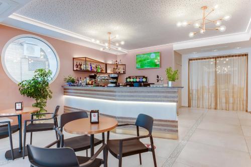 a restaurant with tables and chairs and a bar at Romagna Suite Hotel in Gatteo a Mare