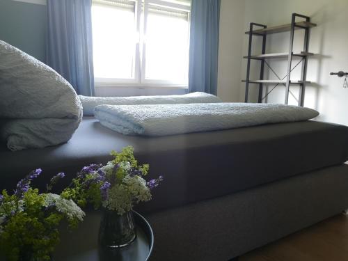 a bedroom with two beds and flowers on a table at Haus zur lachenden Lieselotte I 5 Minuten zu Fuß zum kostenlosen Naturbad I Messenähe I Waldnähe in Postbauer-Heng
