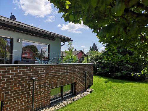 a brick retaining wall next to a house at Haus zur lachenden Lieselotte I 5 Minuten zu Fuß zum kostenlosen Naturbad I Messenähe I Waldnähe in Postbauer-Heng