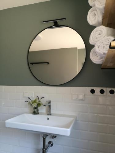 a bathroom with a white sink and a mirror at Haus zur lachenden Lieselotte I 5 Minuten zu Fuß zum kostenlosen Naturbad I Messenähe I Waldnähe in Postbauer-Heng