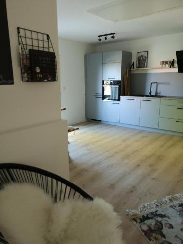 a living room with a couch and a kitchen at Haus zur lachenden Lieselotte I 5 Minuten zu Fuß zum kostenlosen Naturbad I Messenähe I Waldnähe in Postbauer-Heng