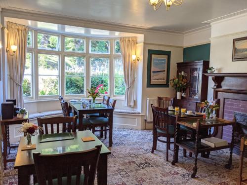 a dining room with tables and chairs and a fireplace at The Denes in Lynton