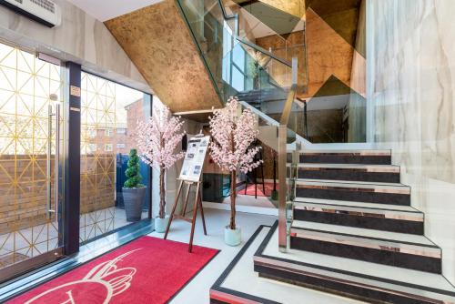 a lobby with stairs and trees in a building at Work-Ready Apartment - Reliable and Relaxing - Apartment 3 in Gillingham