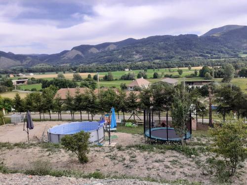 a playground with two trampols in the sand with mountains in the background at Mon ecrin de nature rez de jardin in Seyne