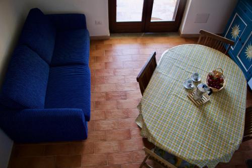 an overhead view of a table and a blue couch at Casa THE NEST - Il Nido sul Mare in Badesi
