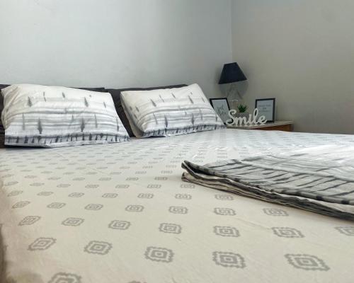 un letto con lenzuola e cuscini bianchi di Kalamata Home #2 a Kalamáta