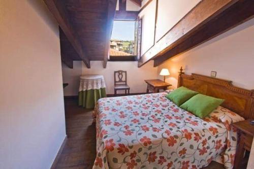 a bedroom with a large bed and a window at Hospedaje Octavio in Santillana del Mar