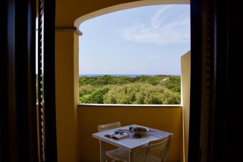 a table and chair in a room with a window at Casa THE NEST - Il Nido sul Mare in Badesi