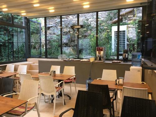 un restaurante con mesas, sillas y ventanas grandes en Nuray Hotel, en Estambul