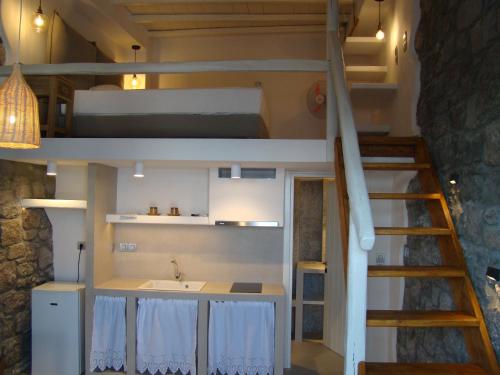 a room with a bunk bed and a kitchen and a sink at Efi's Apartments in Plaka Milou