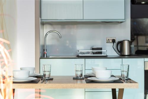 a kitchen with a table with plates and glasses at Perfect for Work Stays - Apartment 4 in Gillingham