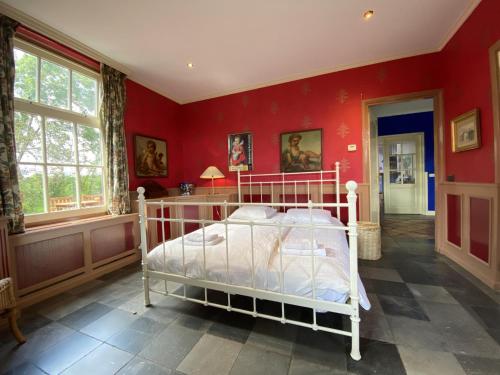 a bedroom with a white bed in a red wall at De Meerenhoeve in Mill