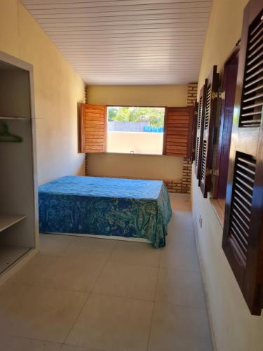 a bedroom with a bed in a room with a window at Casa de ferias - Ferienhaus - House for holiday! in Uruau