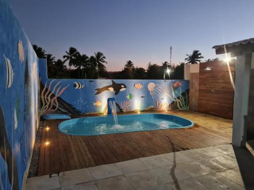 a swimming pool in the backyard of a house with a mural at Casa de ferias - Ferienhaus - House for holiday! in Uruau