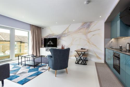 a living room with a kitchen with blue cabinets at Stay for Work - Spotless and Stress-Free - Apartment 5 in Gillingham