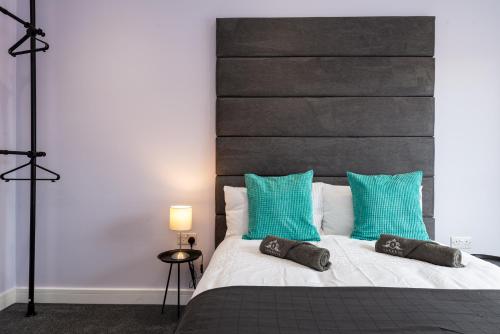 een slaapkamer met een groot bed met blauwe kussens bij Your Apartment Awaits! in Gillingham